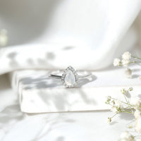 Pear-shaped moonstone halo engagement ring with diamond accents by Rosec Jewels, showcasing a detailed, elegant ring design.