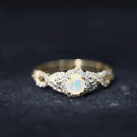 Vintage-style engagement ring with real Ethiopian opal center stone, diamond accents, and a criss-cross shank by Rosec Jewels.