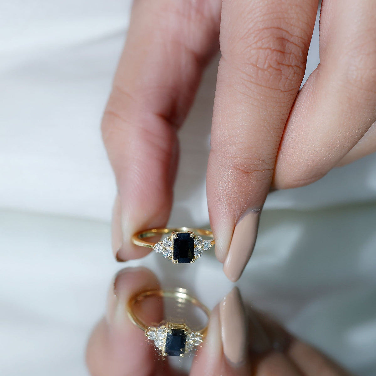 Emerald cut black diamond solitaire ring with diamond trio accents from Rosec Jewels, showcasing a sleek, elegant jewelry design.