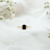Emerald cut black diamond solitaire ring with diamond trio accents from Rosec Jewels, showcasing the elegant black gemstone and sparkling side stones.
