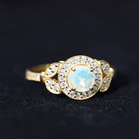 Vintage-inspired Ethiopian rainbow opal engagement ring with diamond halo, showcasing colorful gemstone and elegant design.