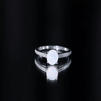Natural 1.2 carat Ethiopian opal oval engagement ring with diamond side stones, showcasing a stunning gemstone setting.
