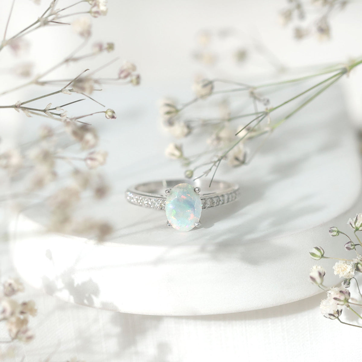 Natural 1.2 Carat Ethiopian Opal oval engagement ring with diamond side stones from Rosec Jewels, showcasing a stunning gemstone and elegant design.