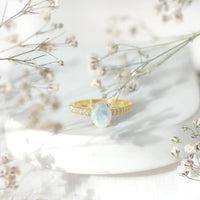 Oval Ethiopian opal engagement ring with diamond side stones, set in a rose gold band, from Rosec Jewels.
