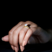 Natural 1.2 carat Ethiopian opal oval engagement ring with diamond side stones, featuring a rose gold band and intricate design.