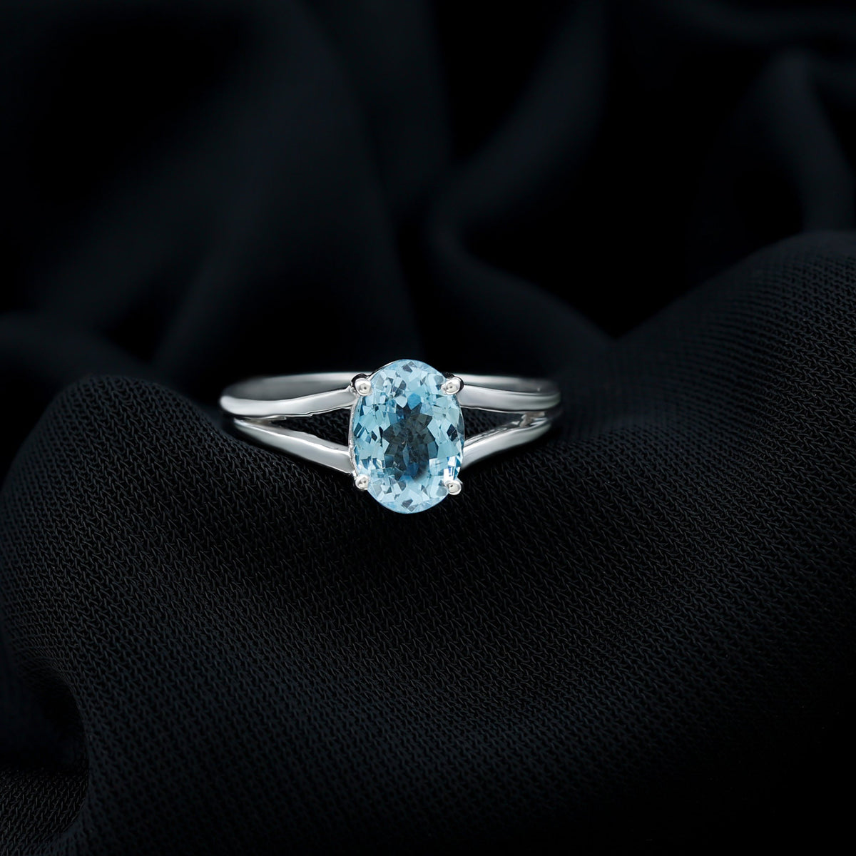 Genuine oval aquamarine solitaire engagement ring with split shank design by Rosec Jewels, showcasing the elegant gemstone setting.