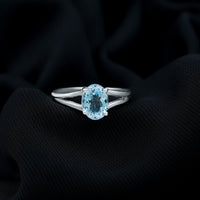 Genuine oval aquamarine solitaire engagement ring with split shank design by Rosec Jewels, showcasing the elegant gemstone setting.