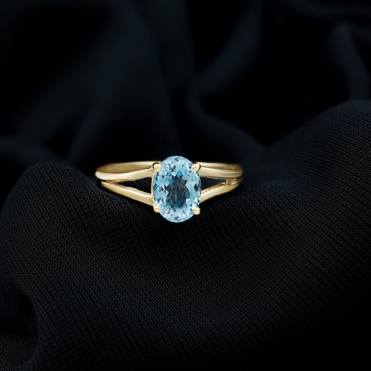 Genuine oval aquamarine solitaire engagement ring with a split shank design from Rosec Jewels, showcasing a sparkling blue gemstone.