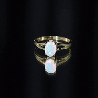 Oval Ethiopian rainbow opal engagement ring with split shank design, featuring a 1.2 carat genuine gemstone and gold band.