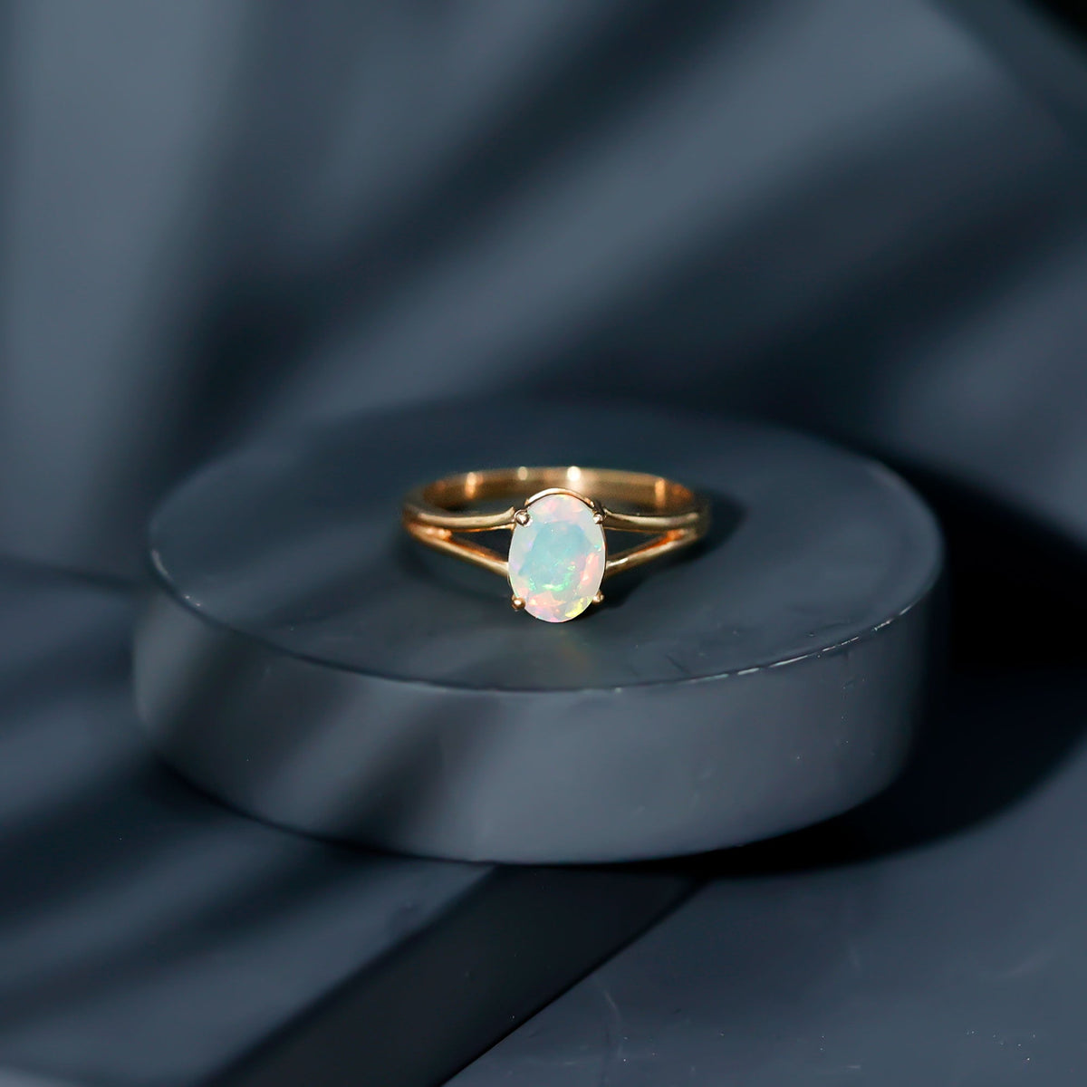Oval Ethiopian rainbow opal engagement ring with split shank in 1.2 carats, featuring vibrant rainbow colors and elegant design.