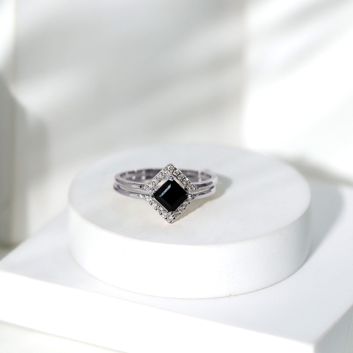 Black onyx and diamond princess cut engagement ring with ring guard, featuring elegant design and sparkling gemstones.