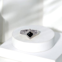 Black onyx and diamond princess cut engagement ring with ring guard, featuring elegant design and sparkling gemstones.