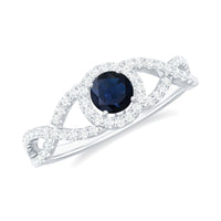 Criss cross shank blue sapphire and diamond halo engagement ring by Rosec Jewels featuring a central sapphire surrounded by diamonds.