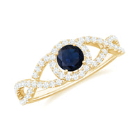 Blue sapphire and diamond halo engagement ring with criss-cross shank by Rosec Jewels, showcasing intricate design and sparkling gemstones.