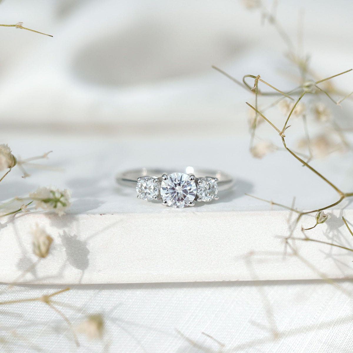 Rosec Jewels certified moissanite three stone engagement ring for women featuring sparkling gemstones and elegant silver band.