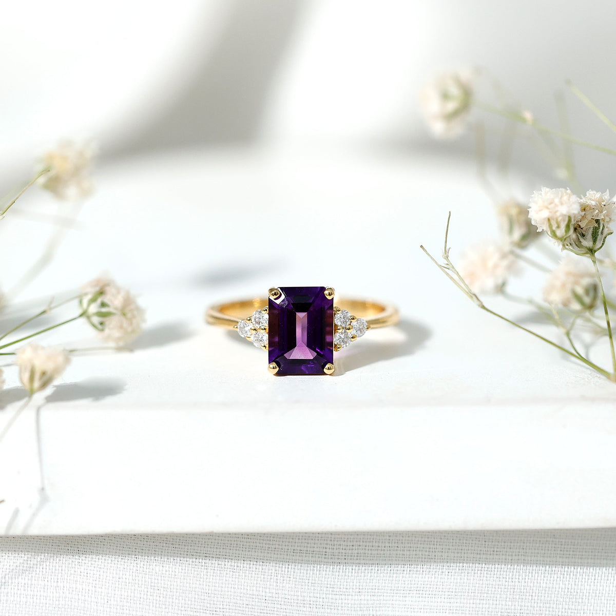 Emerald cut 1.4 carat Amethyst engagement ring with diamond trio accents by Rosec Jewels, showcasing a silver band and intricate design.