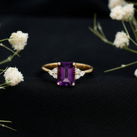 Emerald cut amethyst engagement ring with diamond trio accents by Rosec Jewels, featuring a 1.4 carat purple gemstone.