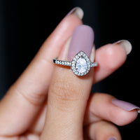 Rosec Jewels zircon teardrop halo engagement ring with sparkling central stone and intricate band design.