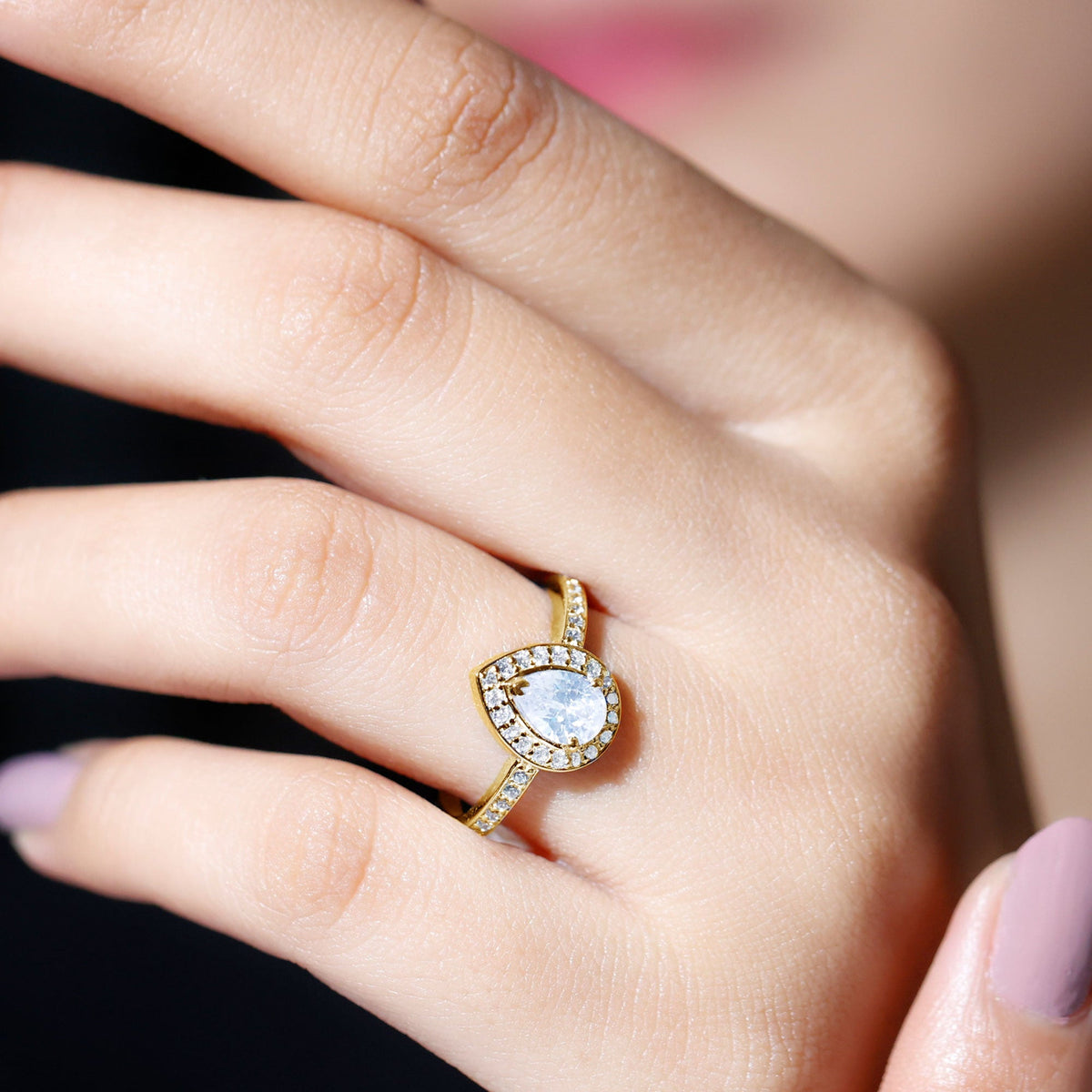 Rosec Jewels zircon teardrop halo engagement ring with sparkling central stone and intricate band detail.