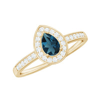 Pear-shaped London Blue Topaz engagement ring with real diamond halo, crafted by Rosec Jewels, showcasing intricate detail and sparkle.