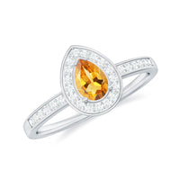 Natural 5x7mm pear-shaped citrine engagement ring with diamond halo by Rosec Jewels, featuring a gold band and intricate design.