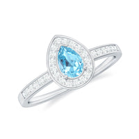 Natural pear-shaped aquamarine engagement ring with diamond halo, featuring elegant rose gold band and intricate detailing.