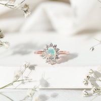 Oval Ethiopian opal engagement ring with diamond halo, featuring a rose gold setting and intricate detailing.