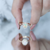Ethiopian opal oval engagement ring with diamond halo by Rosec Jewels, showcasing a sparkling stone and intricate band detail.