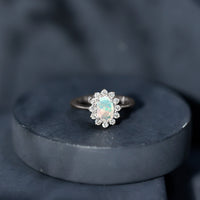 Oval Ethiopian Opal engagement ring with diamond halo, featuring a Rosec Jewels design and intricate silver band.