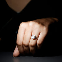 Princess Diana inspired moonstone engagement ring with diamond halo, featuring a delicate silver band and intricate detailing.