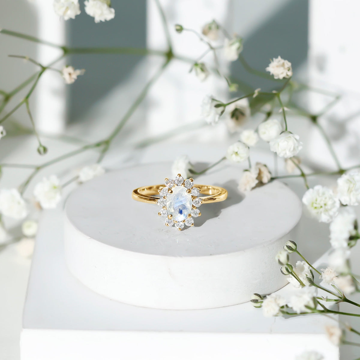 Princess Diana inspired moonstone engagement ring with diamond halo from Rosec Jewels, showcasing a luminous moonstone and sparkling diamonds.