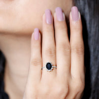 Oval cut black onyx engagement ring with diamond halo and rose gold band by Rosec Jewels, showcasing intricate design and sparkle.