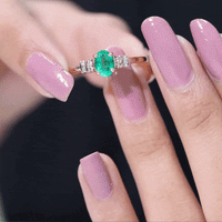 Natural emerald and diamond engagement ring for her featuring a central emerald gemstone surrounded by sparkling diamonds.