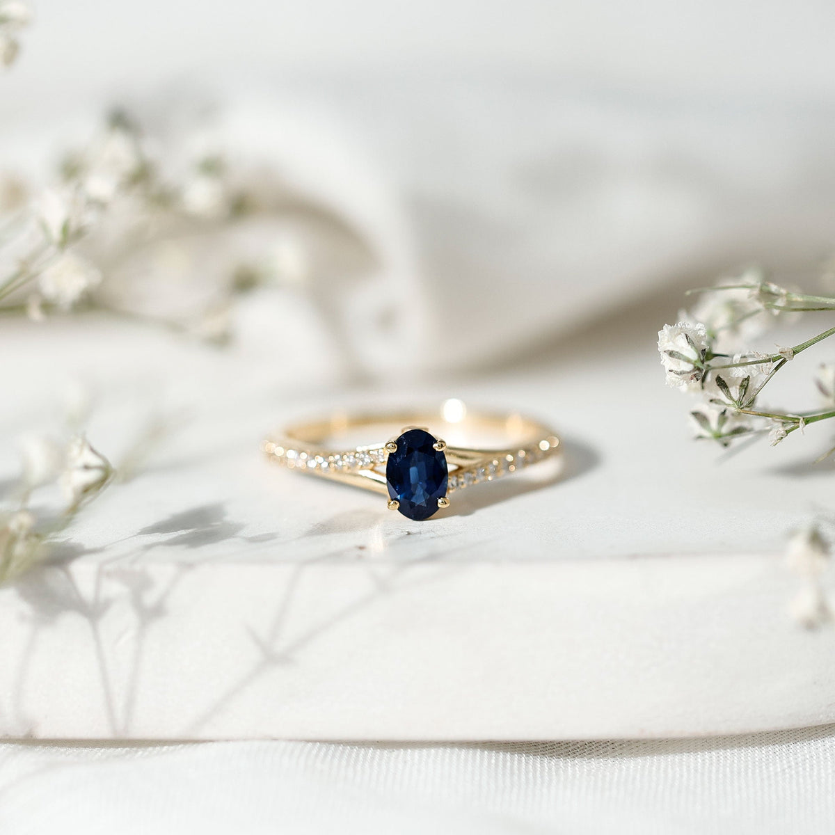 Natural 0.6 carat blue sapphire engagement ring with diamond split shank from Rosec Jewels, showcasing elegant design and fine craftsmanship.
