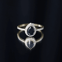 Lab grown black diamond teardrop engagement ring with white diamond halo by Rosec Jewels, showcasing sparkling gemstones and elegant design.