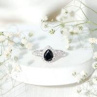 Lab grown black diamond teardrop engagement ring with white diamond halo by Rosec Jewels, showcasing the elegant design and sparkling stones.