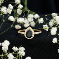 Lab grown black diamond teardrop engagement ring with white diamond halo, featuring Rosec Jewels branding, shown on a white background.
