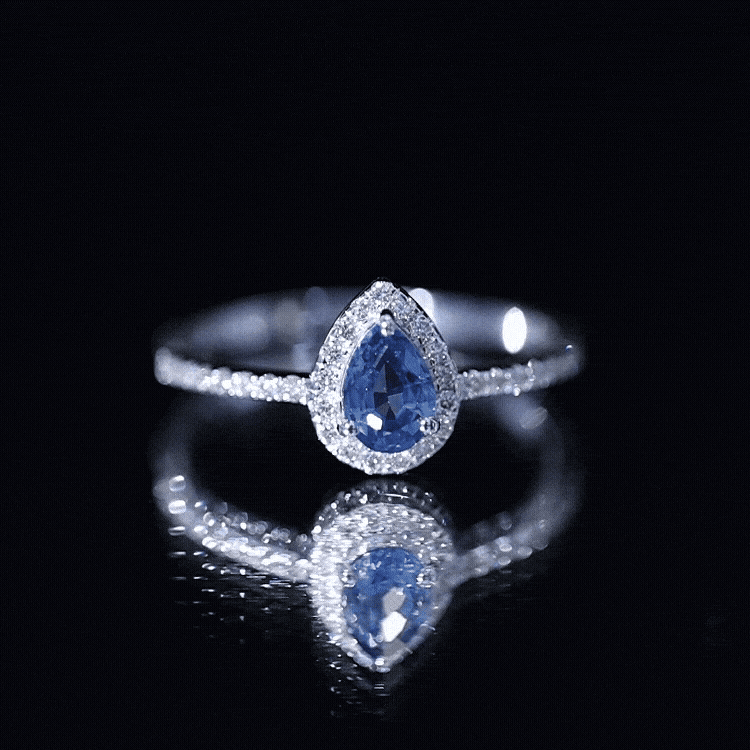 Natural half carat blue sapphire teardrop engagement ring with diamond halo from Rosec Jewels, featuring a white gold band and intricate design.