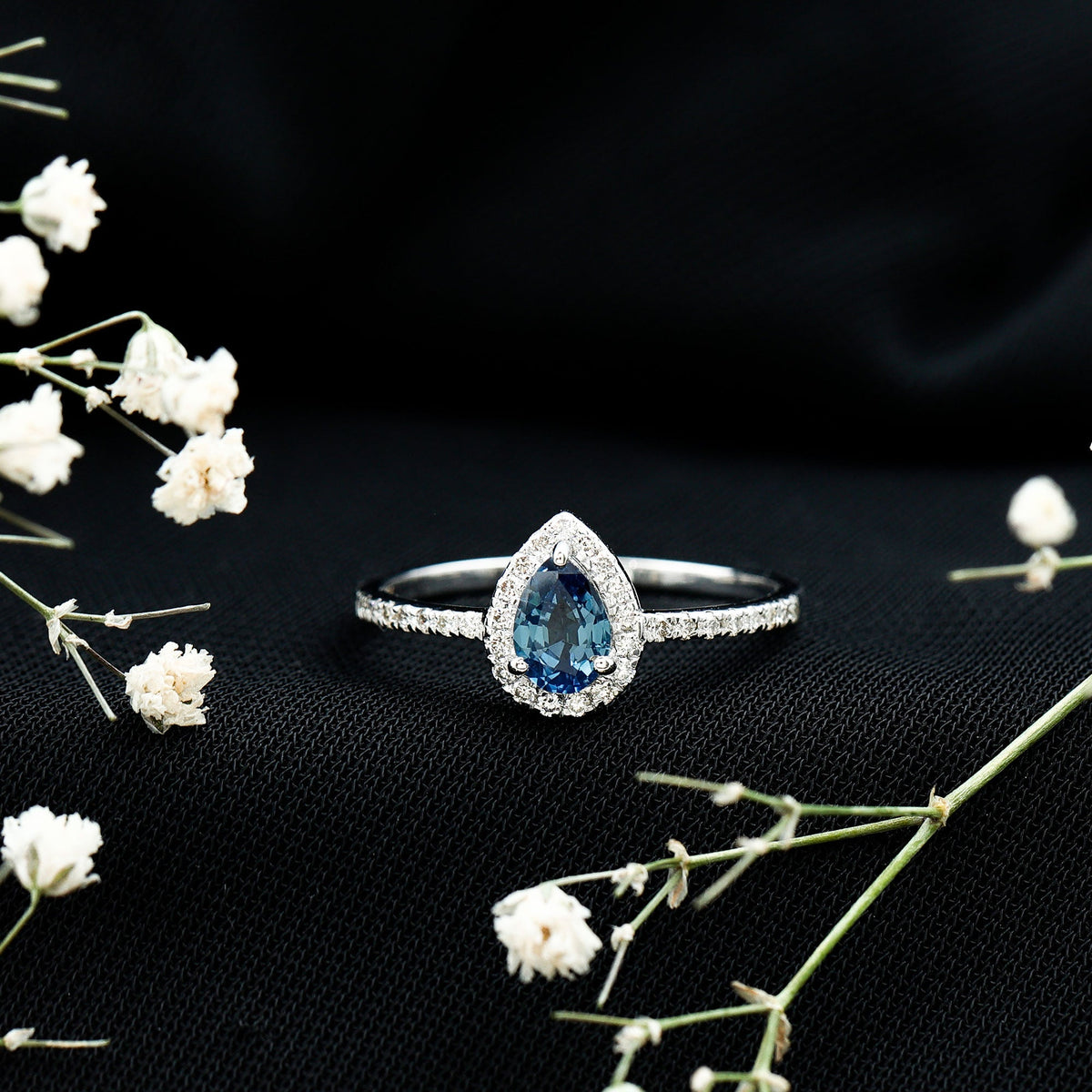 Natural half carat blue sapphire teardrop engagement ring with diamond halo by Rosec Jewels, showcasing a stunning blue sapphire center.