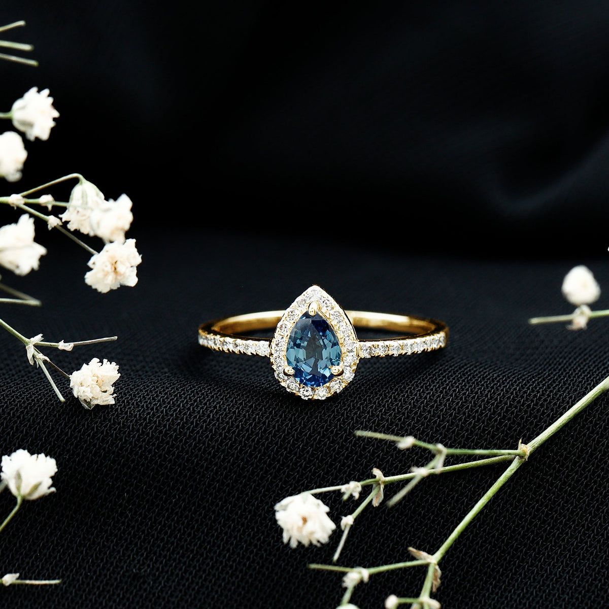 Natural half carat blue sapphire teardrop engagement ring with diamond halo, showcasing elegant jewelry from Rosec Jewels.