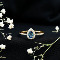 Natural half carat blue sapphire teardrop engagement ring with diamond halo, showcasing elegant jewelry from Rosec Jewels.