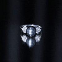 Nature-inspired Tahitian pearl engagement ring with diamond accents, featuring a rose gold band and intricate design details.