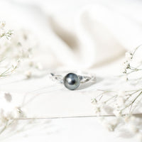 Tahitian pearl and diamond crossover engagement ring by Rosec Jewels featuring a pearl and sparkling diamonds on a gold band.