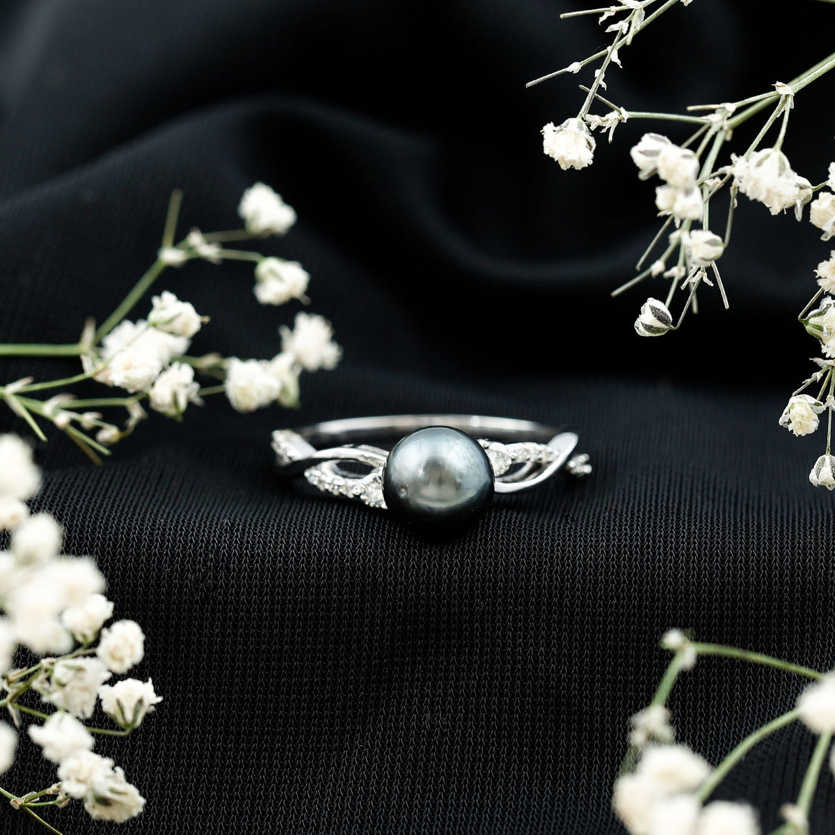 Tahitian pearl and diamond crossover engagement ring by Rosec Jewels featuring a central pearl with diamond accents on a gold band.