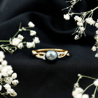 Tahitian pearl and diamond crossover engagement ring by Rosec Jewels featuring a pearl center with diamond accents.