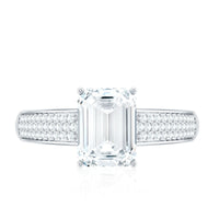 Emerald cut moissanite side stone engagement ring from Rosec Jewels featuring a central gemstone and side stones on a silver band.