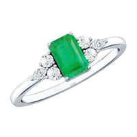Emerald cut emerald engagement ring with diamond trio accent stones from Rosec Jewels, showcasing elegant design and sparkling gemstones.