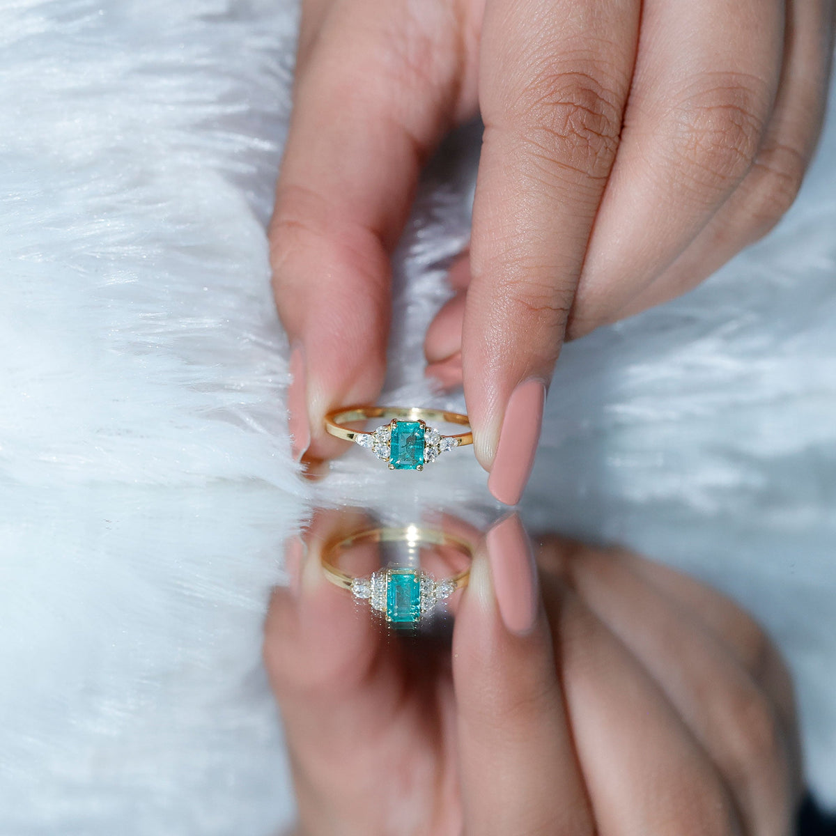 Emerald cut emerald engagement ring with diamond trio from Rosec Jewels, showcasing a stunning center gemstone and side diamonds.
