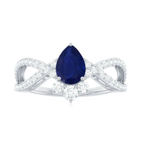 Pear-shaped blue sapphire engagement ring with diamond crossover detail, set in a elegant ring from Rosec Jewels.