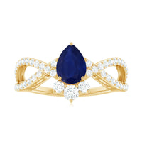 Pear-shaped blue sapphire engagement ring with diamond crossover design by Rosec Jewels, showcasing a sparkling blue gemstone and intricate band.